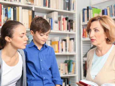 a mother and primary pupil talking to a teacher