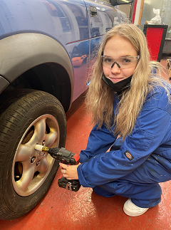 An apprentice working on a car