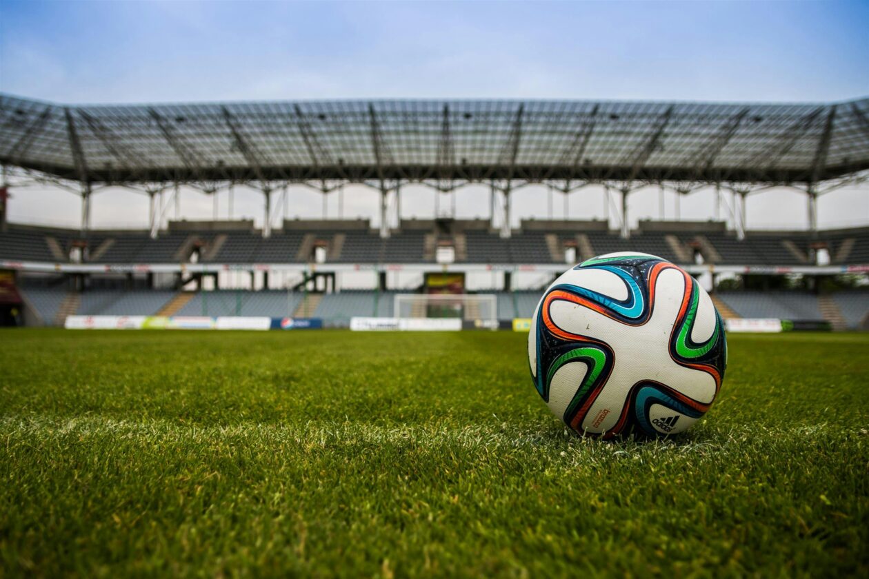 A football on a playing field. Photo by Pixabay: https://www.pexels.com/photo/soccer-ball-on-grass-field-during-daytime-46798/