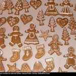 A variety of gingerbread cookies decorated with white icing, featuring shapes like trees, hearts, and gingerbread people.