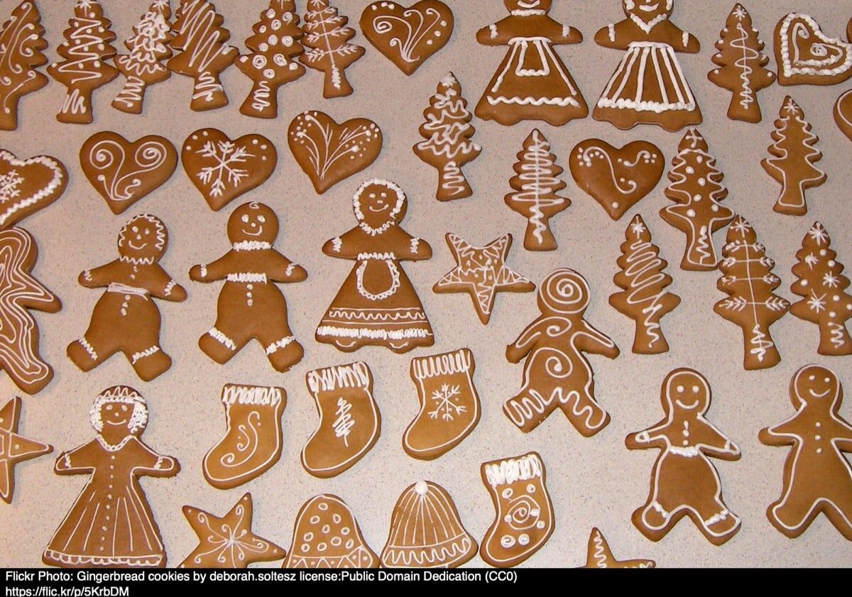 A variety of gingerbread cookies decorated with white icing, featuring shapes like trees, hearts, and gingerbread people.