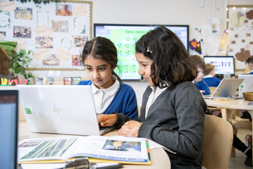 two children using a laptop