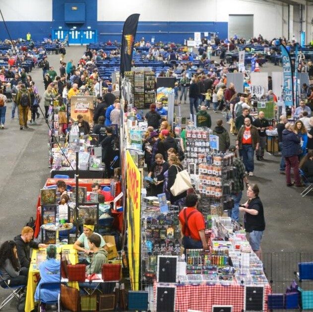 a large crowd of people exploring tabletop games at a convention