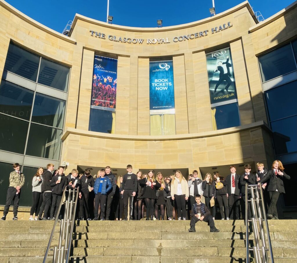 A group of pupils stand in front of the Glasgow Royal Concert Hall on Buchanan Street. 