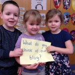 Pupils holdign sign "What do you think of this Blog?"