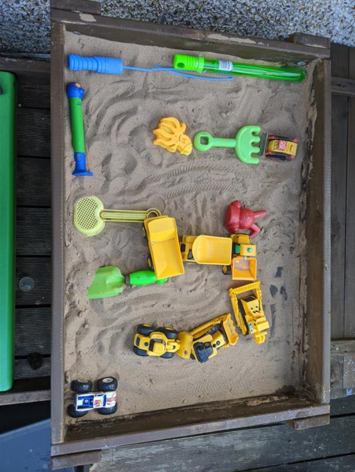 maze in sand pit created with assorted plastic toys