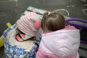 two pre school children learning together using a mobile device.