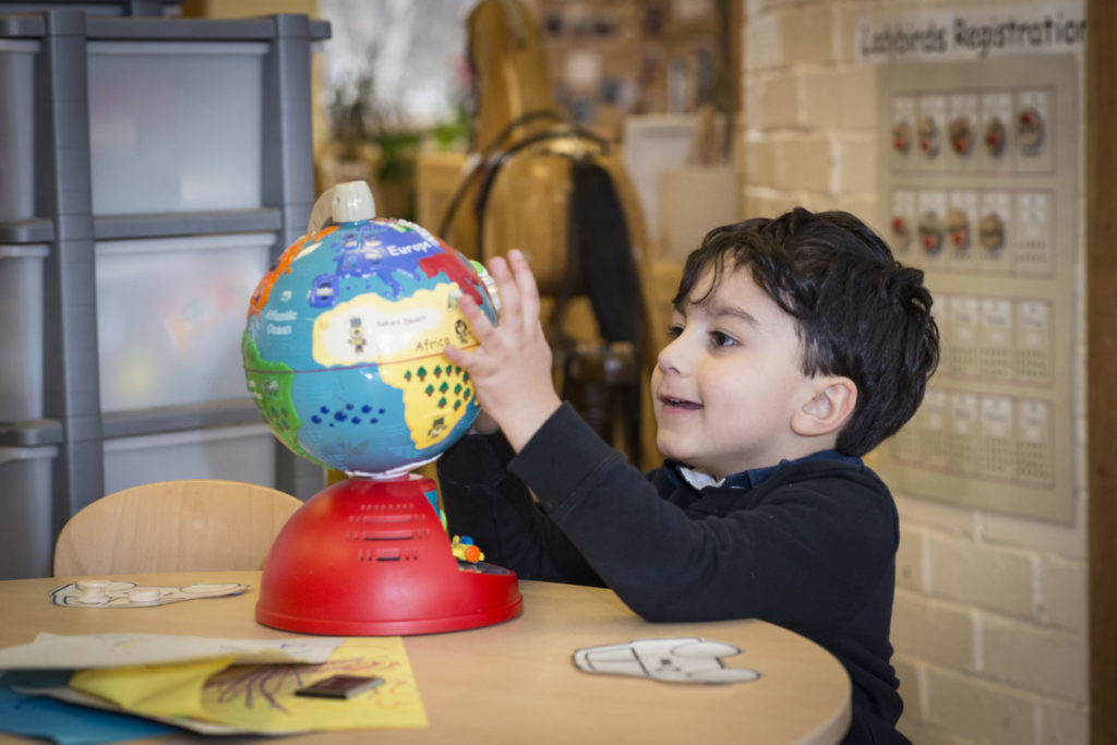 This image displays a child playing with a globe.