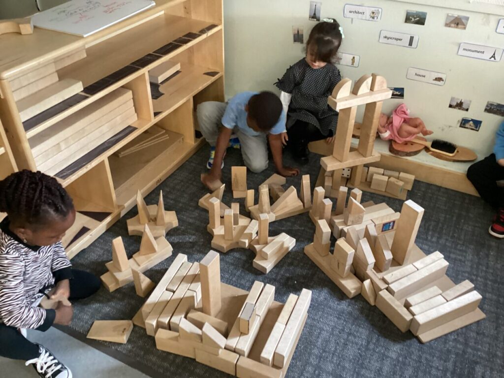 Children building a town with wooden blocks.