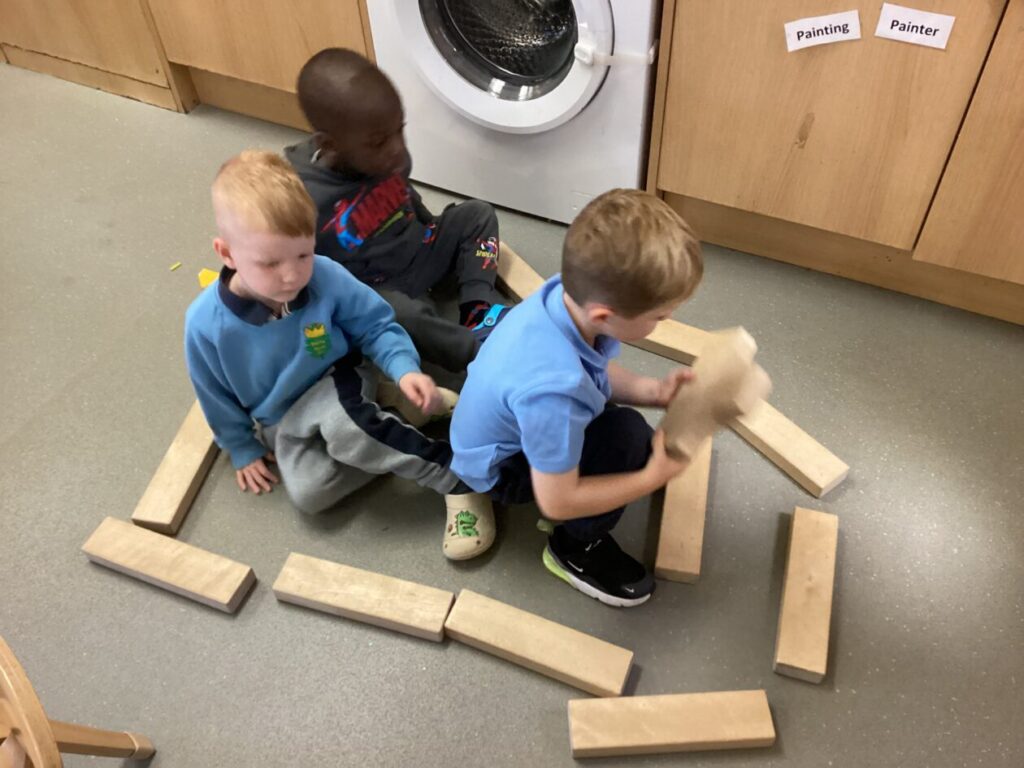 Children building a car with wooden blocks.