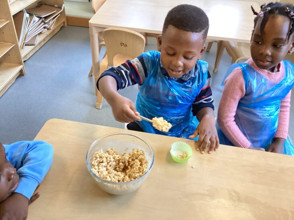 Scooping chocolate crispies into a cup cake case.