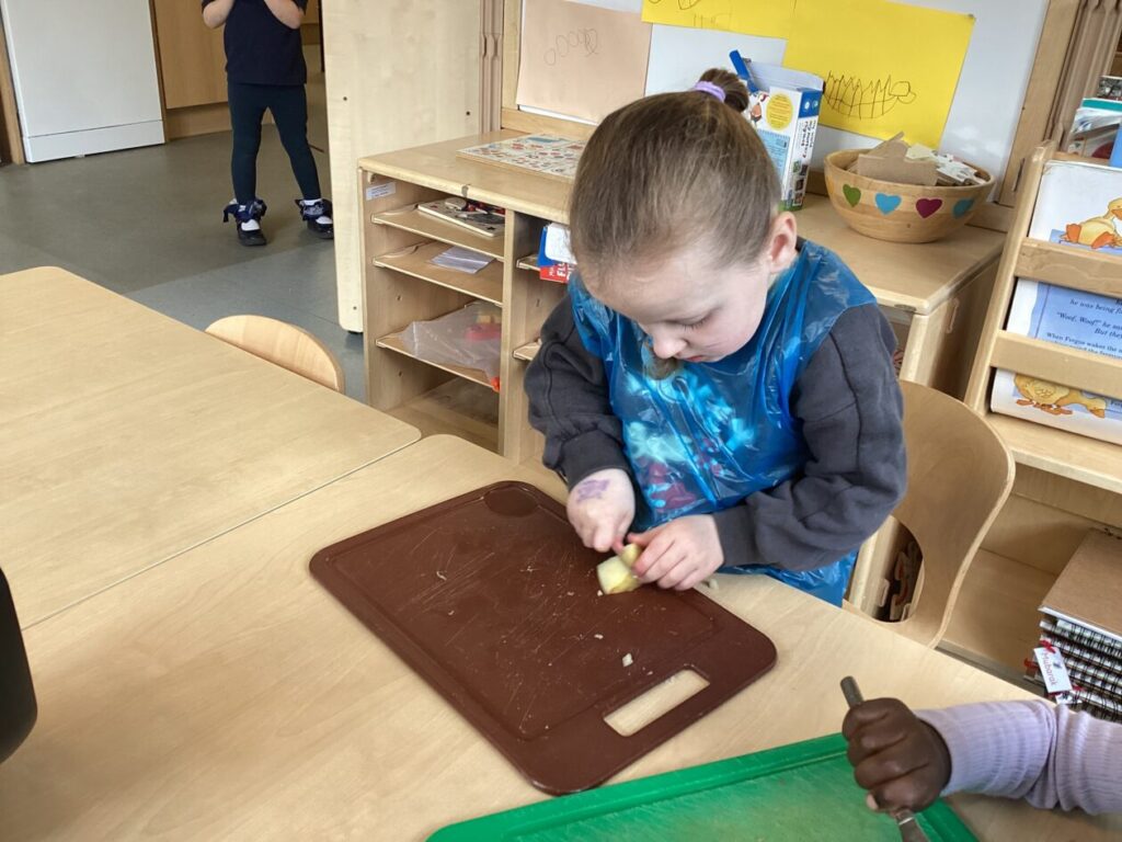 Girl chopping vegetables on a chopping board.