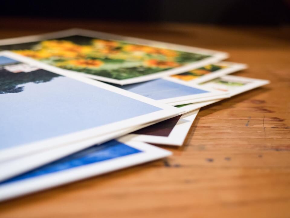 A pile of photos on a wooden table