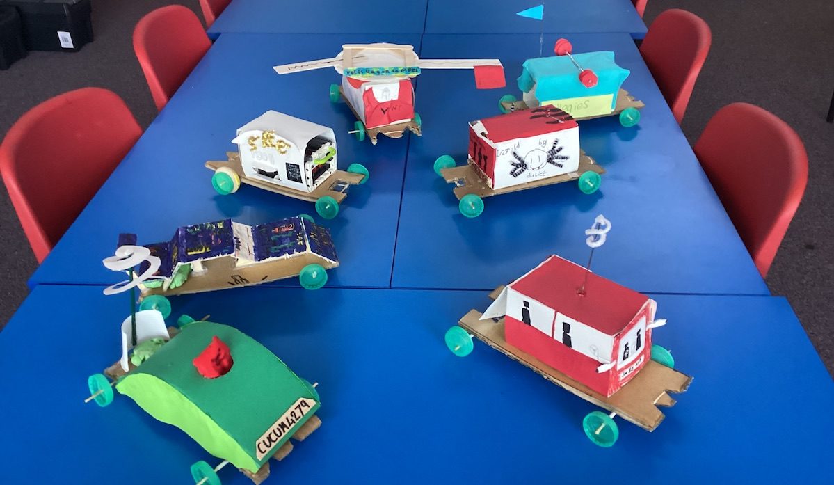 several elastic band cars designed and made by pupils in class.