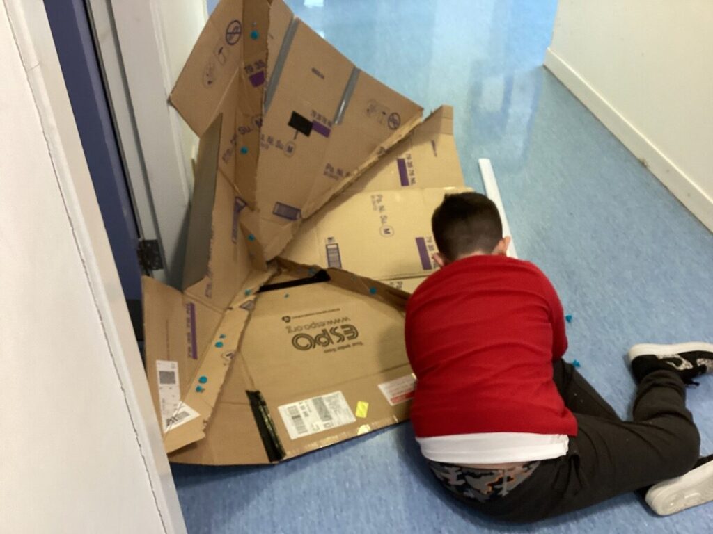 Child working on cardboard building