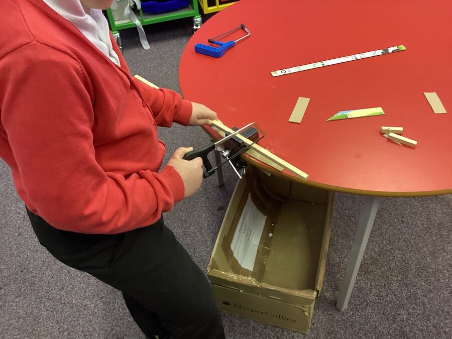 Child using a saw and vice to cut wood