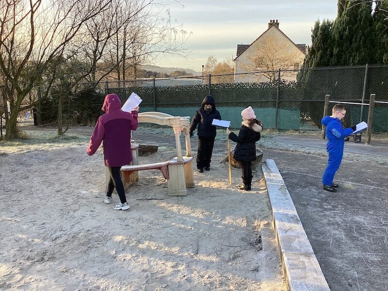 Children measuring in the playground