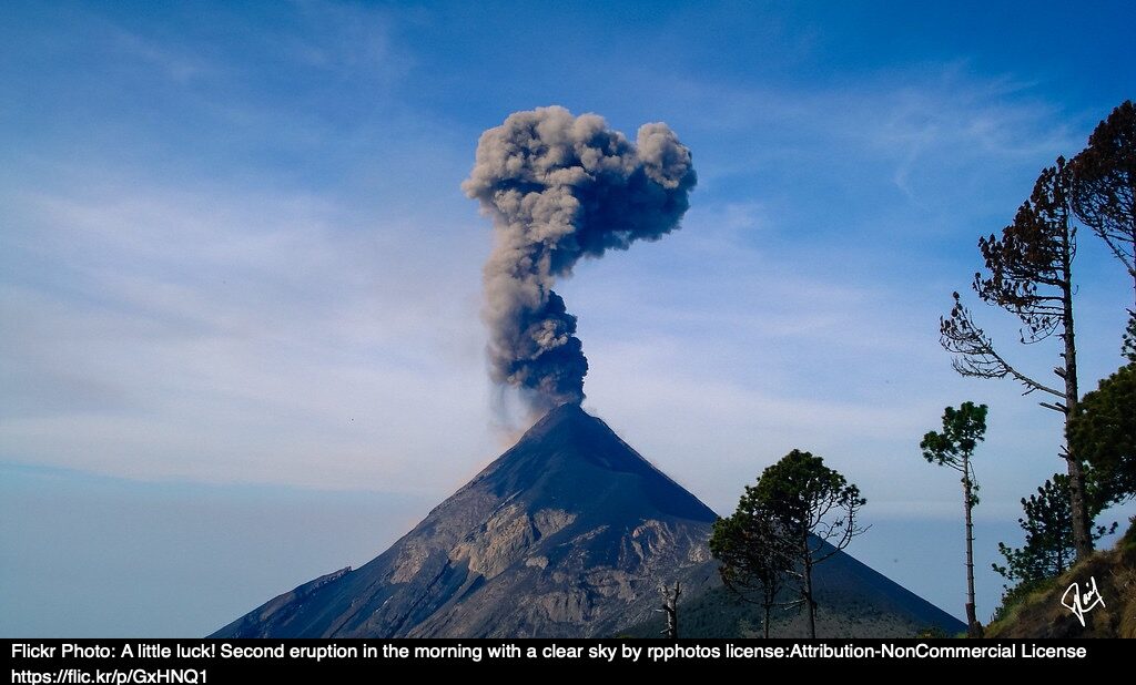 A volcano with smoke coming out the top.